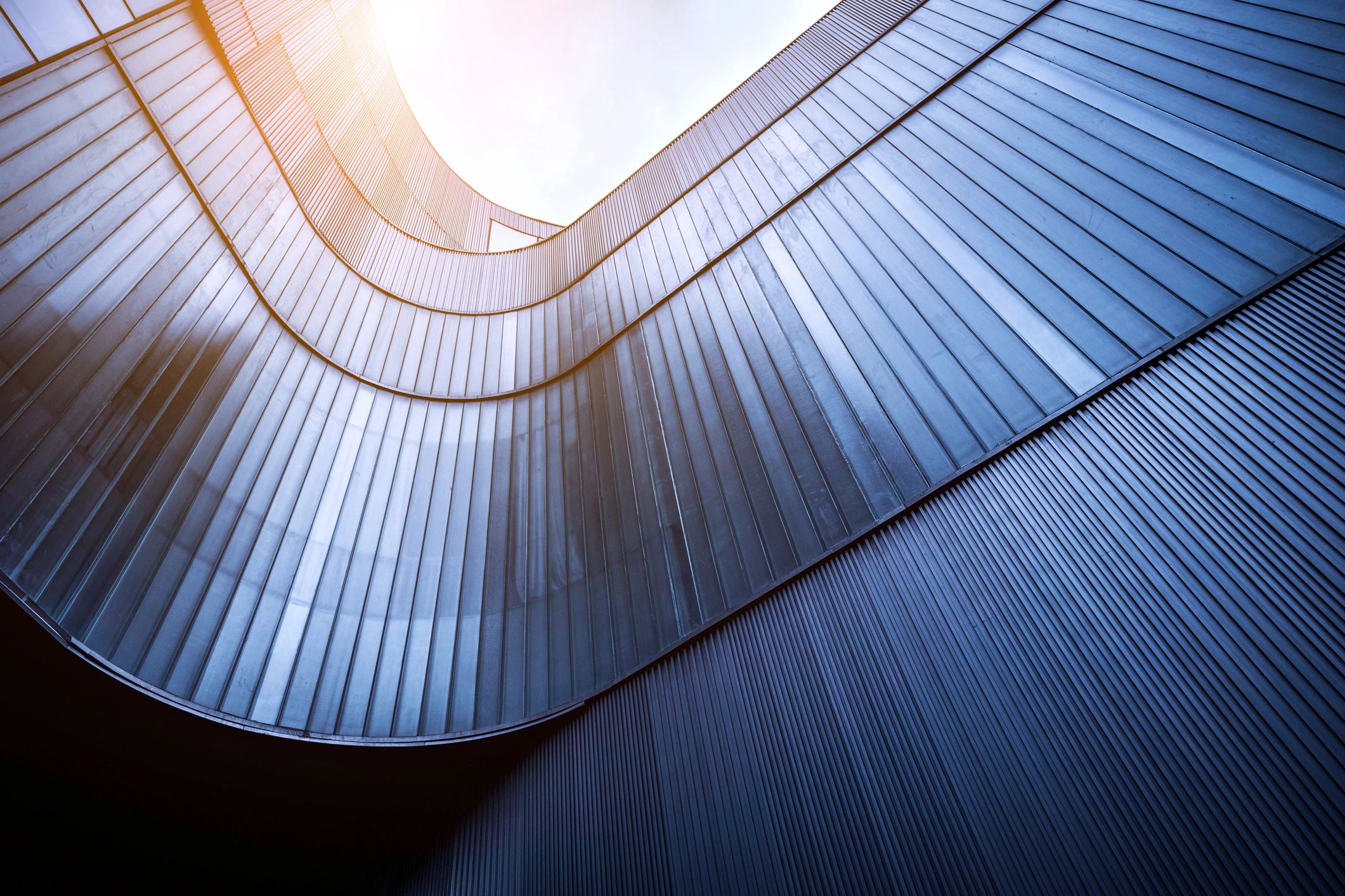 Modern commercial facade with curved glass and metal lines